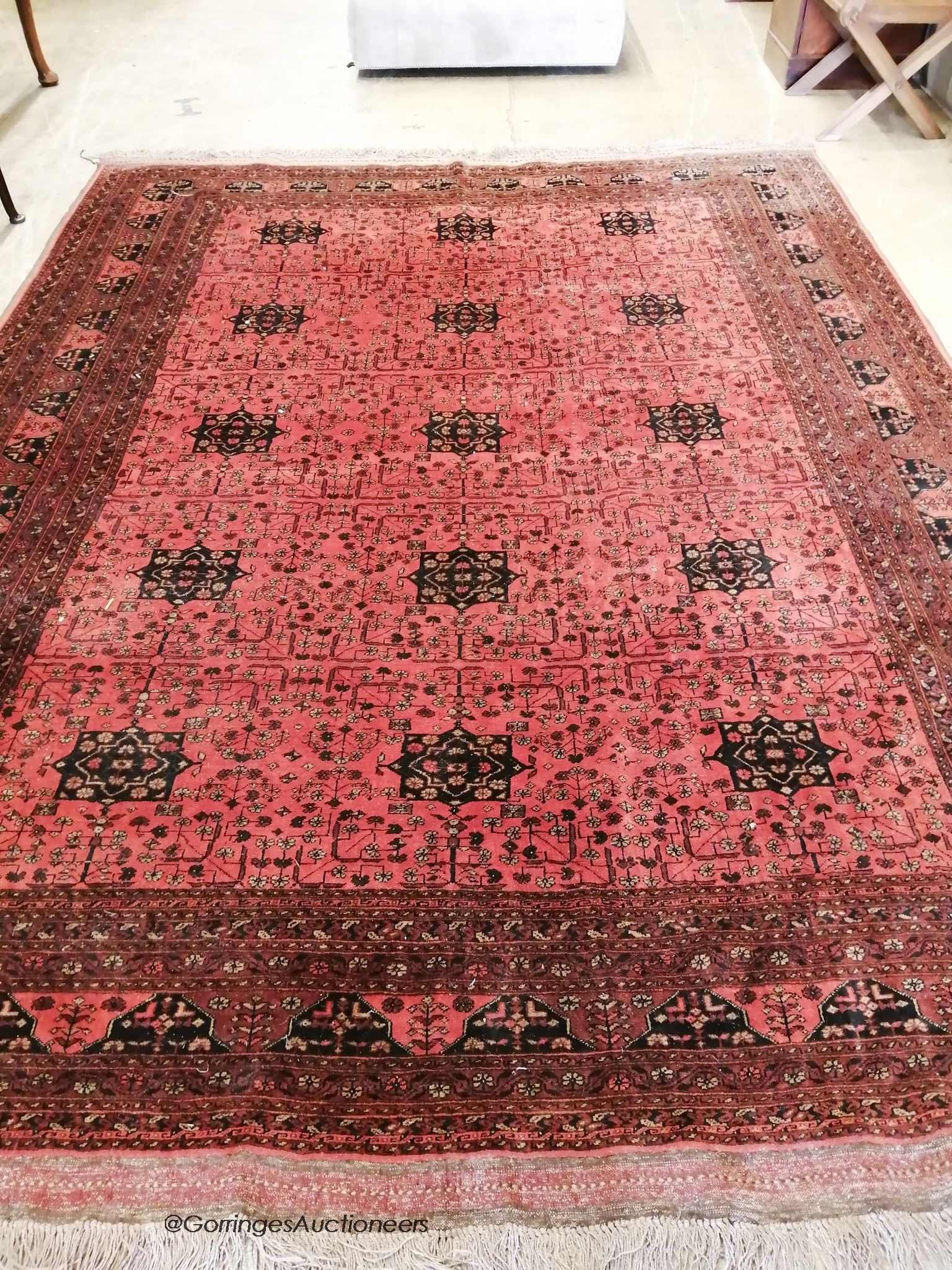 An Afghan red ground carpet, 360 x 260cm